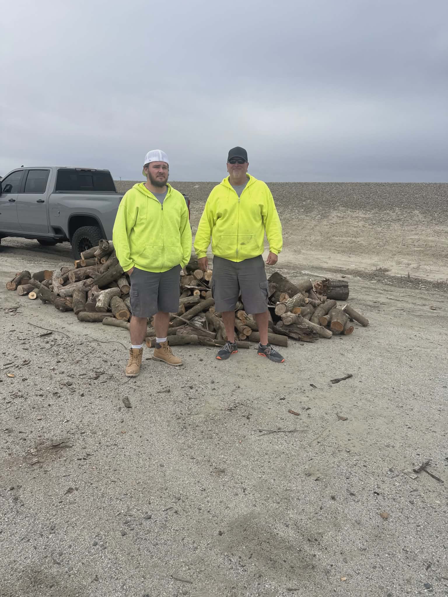 Two workmen standing with delivered wood